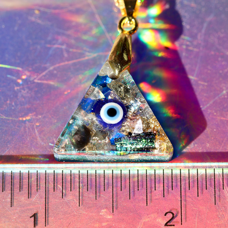 Triangular pendant with eye design on a colorful background