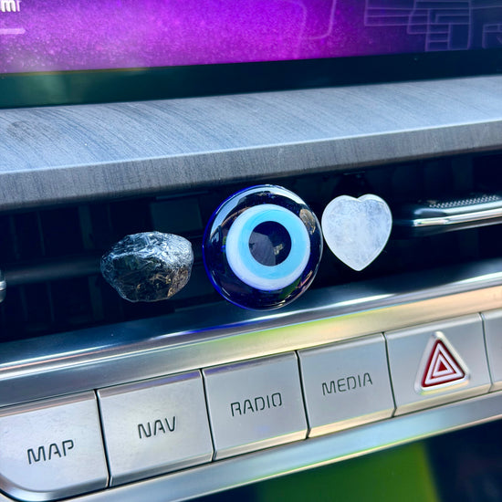 Car dashboard with control buttons and a screen displaying a purple interface.